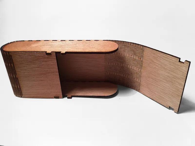 A plywood box whose curved side is made from a laser-cut living hinge: rows of fine slits that let the flat sheet bend
